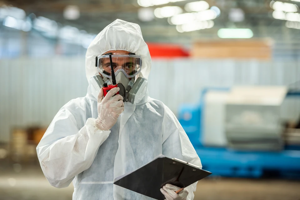 Technicien en combinaison orange effectuant maintenance sur embarcation maritime
