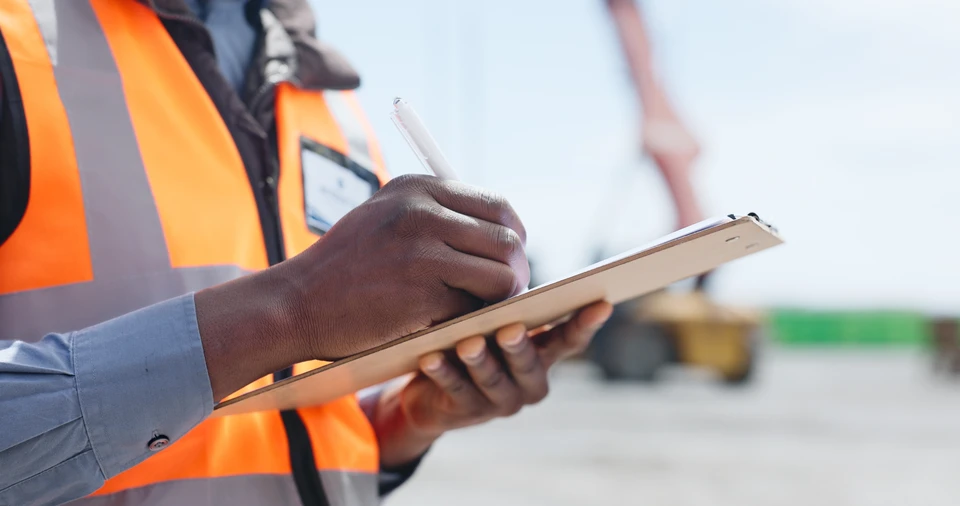Deux ingénieurs en équipements de protection individuelle inspectent une canalisation industrielle sur un chantier extérieur