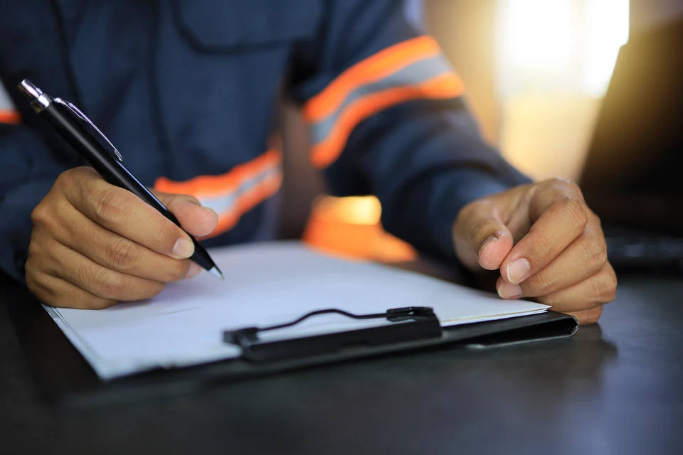 Bureau professionnel avec personne écrivant à la main sur documents papier
